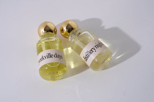 Two small glass bottles with gold caps and labels on a white background